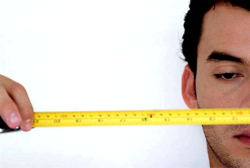 Un hombre con una regla mide el pene antes de la ampliación. 